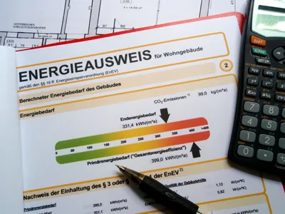 Energieausweis mit energetischer Farbskala und Taschenrechner