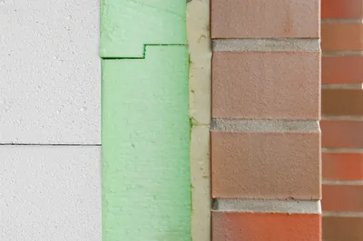 Querschnitt einer gedämmten Außenwand mit mehreren Bauteilschichten