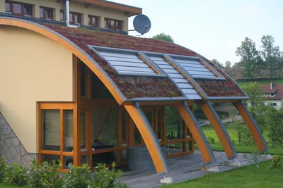 Passivhaus mit großflächiger Verglasung und begrüntem Dach